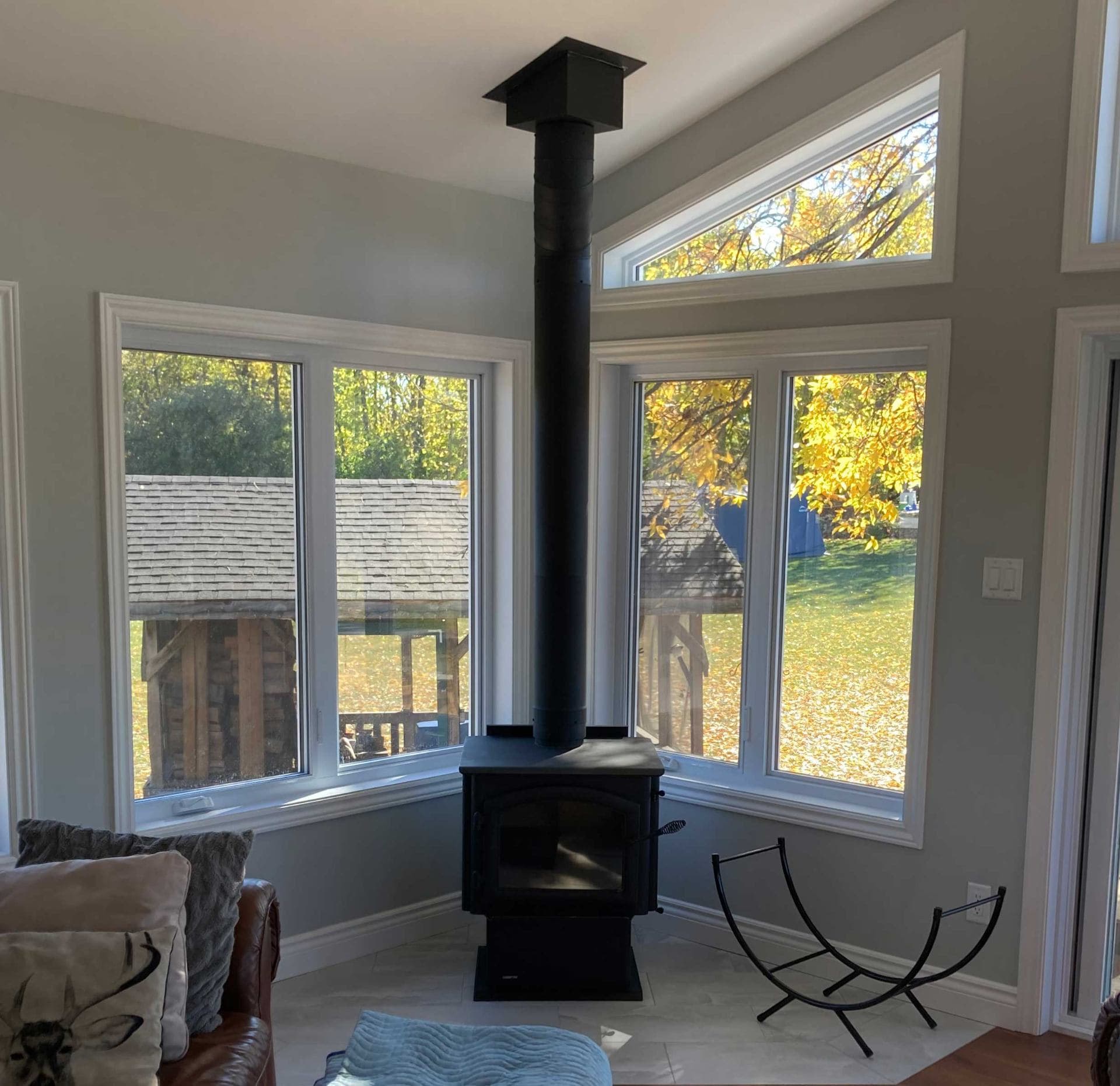 Wood stove in modern living room with windows