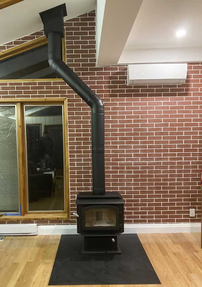Modern wood stove with brick wall backdrop