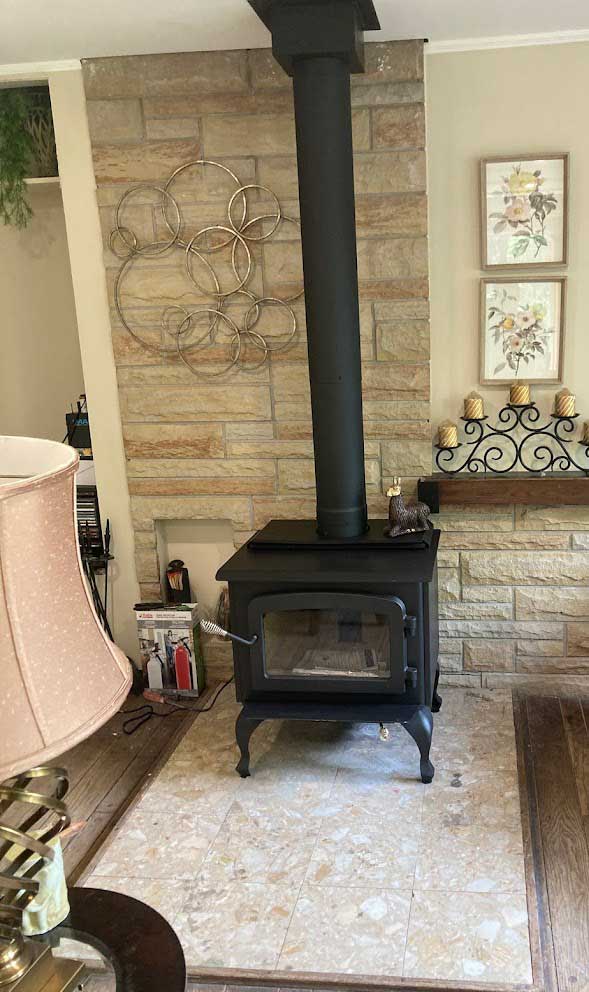Wood stove with stone fireplace backdrop